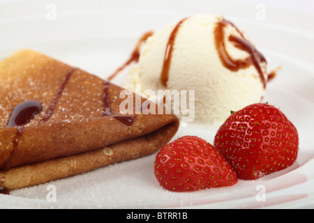 Crêpes délicieux avec des fraises et de la crème glacée sur une plaque Banque D'Images