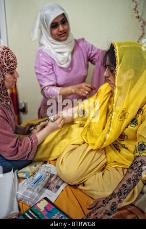 Jeune musulman bride-à-être a élaborer des dessins au henné peints sur ses bras et ses mains par sa fille musulmane ami avant son mariage Banque D'Images