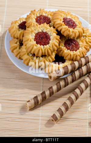 Rouleaux de gaufrettes et biscuits sur le plat blanc Banque D'Images