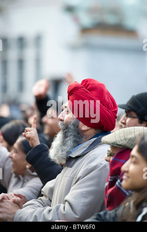 Un homme portant le turban sikh rouge, écoute attentivement pour un discours à l'Diwali Festival tenu à Trafalgar Square, Londres. Banque D'Images