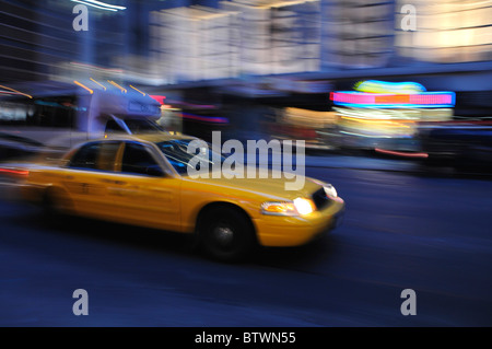 Taxi se précipiter une rue de la ville de nuit dans un flou Banque D'Images