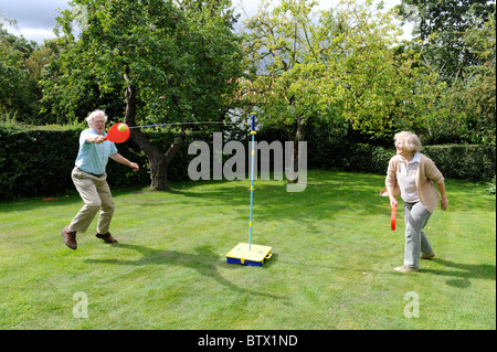 Couple de personnes âgées jouant swingball Banque D'Images