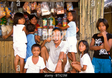 Philippines, Palawan, les enfants et un aîné à l'extérieur d'une construction en bambou de dépanneur dans une petite ville de l'île de Culion. Banque D'Images