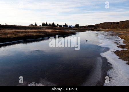 Rivière gelée semi-Oxara avec Thingvalla Kirkja église dans la distance, le Parc National de Thingvellir, Islande. Banque D'Images