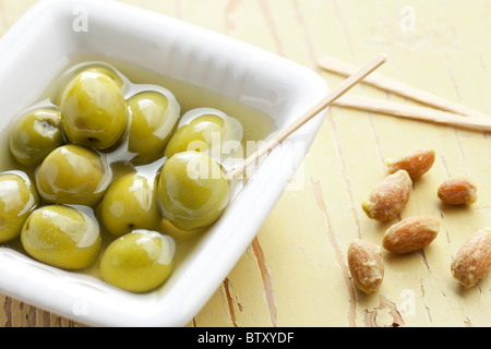 Les olives vertes dans le bol en céramique ancienne table Banque D'Images