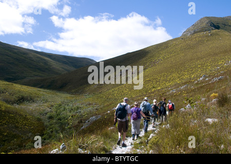 Vue arrière d'un groupe de randonneurs marchant le long d'un sentier dans la campagne montagneuse Banque D'Images