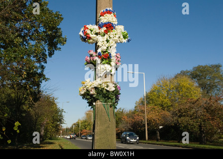 Monument commémoratif à la mémoire d'une victime d'un accident de voiture. Croix de fleurs en plastique Weston Green Surrey Greater London A307 Banque D'Images