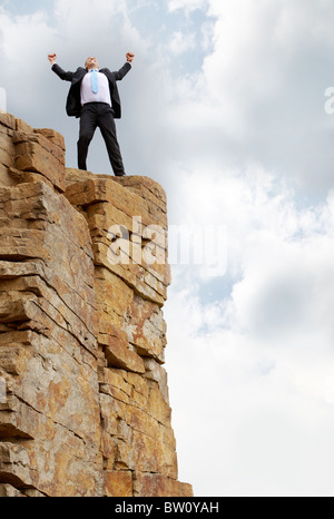 Photo de heureux business man debout sur la montagne Banque D'Images
