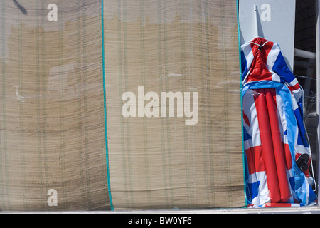 Une union jack flag beach lilo est abandonné en dans une fenêtre d'une boutique de bord de mer dans la région de Weston-super-Mare Banque D'Images