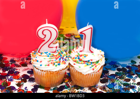 Célébration avec des ballons, des confettis, cupcake, et le nombre 21 bougie. Banque D'Images