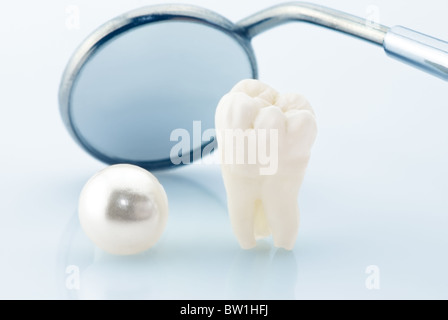 Concept des dents saines. Dent de sagesse humaine naturelle, Pearl et dentaire miroir. Image de couleur bleu Banque D'Images