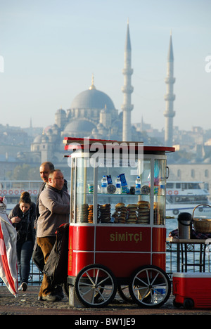 ISTANBUL, TURQUIE. Un étal vendant bretzels simits (soft) par la Corne d'or dans la région de Karakoy, avec la Mosquée Yeni derrière. 2010. Banque D'Images