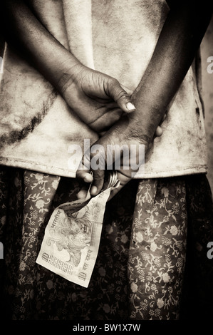 Indian street girl mendier de l'argent, le tenant derrière son dos. L'Andhra Pradesh, Inde. Sépia. Banque D'Images