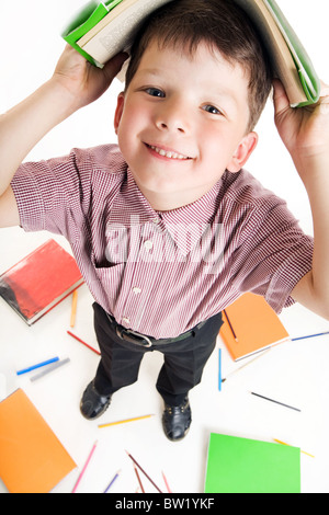 Photo de Fisheye garçon diligent avec livre sur sa tête alors qu'à faire leurs devoirs Banque D'Images