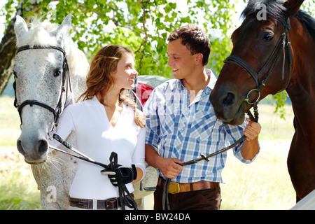 Image de l'heureux couple avec chevaux de pur-sang à l'un l'autre Banque D'Images