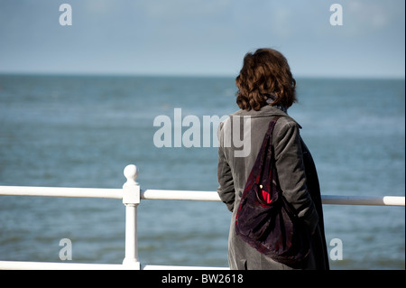 Vue arrière d'une seule femme en voyant la mer, UK Banque D'Images