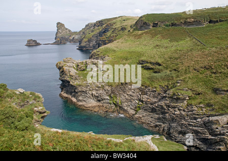 Rocky Valley près de Tintagel sur la côte nord des Cornouailles, avec des rochers et Long Island dans la distance Banque D'Images