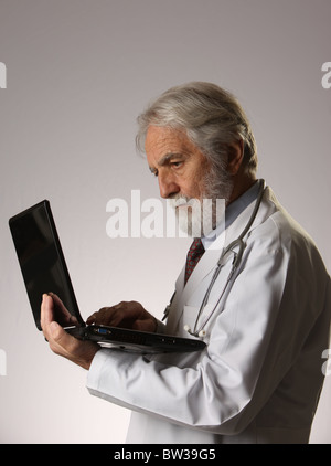 Médecin mature avec ordinateur portable, wearing stethoscope et sarrau blanc, 9 novembre 2010, © Katharine Andriotis Banque D'Images