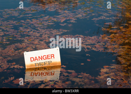 L'eau profonde panneau d'avertissement dans l'étang où le niveau d'eau est de masquer les danger Banque D'Images