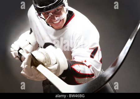 Le joueur de hockey avec l'expression du visage cruel de pointage à l'appareil photo en Banque D'Images