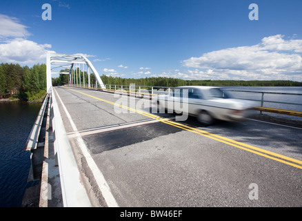 Une voiture en traversant le détroit d'un lac à l'aide d'un pont-route , Finlande Banque D'Images
