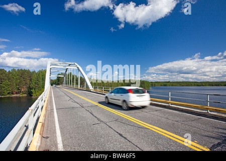 Une voiture en traversant le détroit d'un lac à l'aide d'un pont-route , Finlande Banque D'Images