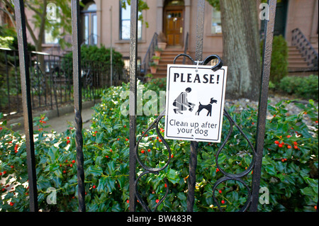 Un signe en face d'une maison en pierre brune dans Brooklyn, NY invite les gens à nettoyer après leurs chiens. Banque D'Images