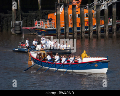 Les spectateurs de prendre des photos de personnes d'un bateau d'aviron dans le port, Whitby, North Yorkshire, Angleterre, Royaume-Uni. Banque D'Images