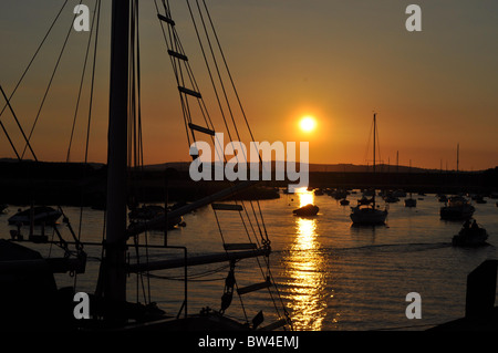 Le coucher de soleil sur Topsham Quay, avec un bateau passant au premier plan. Topsham, Nr Exeter, Devon Banque D'Images