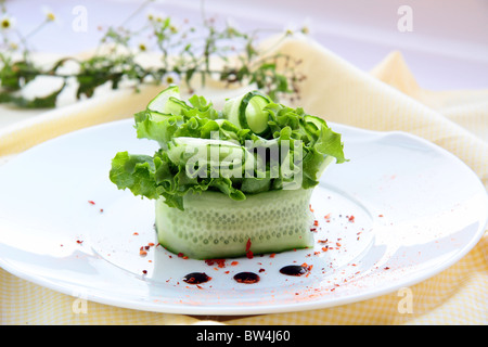 Avec salade de tomates et roquette sur une plaque blanche Banque D'Images