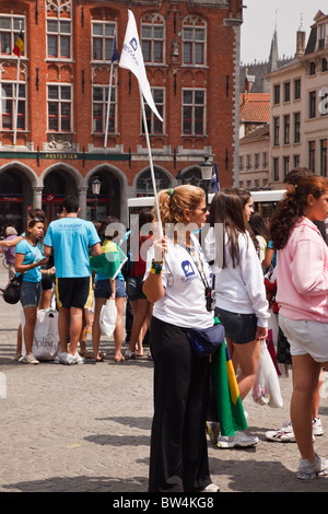 Markt, Bruges, Belgique, Europe. Les touristes shopping guide touristique avec drapeau dans la ville historique Banque D'Images