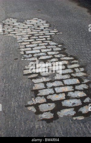 La surface de la route moderne supprimé lors de l'exposition de resurfaçage pavés anciens d'origine, New York City, USA Banque D'Images