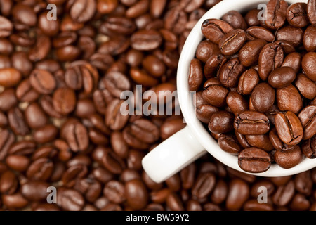 Tasse à espresso avec plein de café torréfié. En arrière-plan sont encore visibles. les fèves de café Banque D'Images