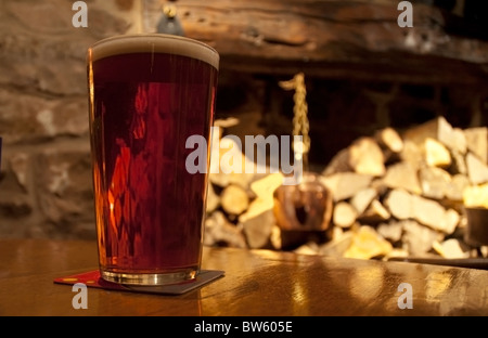 Verre de bière sur la table avec une cheminée et de sciage en arrière-plan Banque D'Images