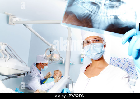 Portrait de l'assistant à la recherche au patient' x-ray la photographie durant l'examen dentaire Banque D'Images