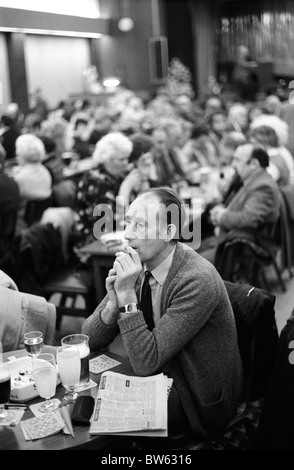 Homme de travail Club samedi soir jouant au Bingo. Fumer seul carte de bingo, courses de chevaux résultats journal des années 1980 Coventry Angleterre Royaume-Uni HOMER SYKES Banque D'Images