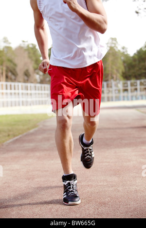 Photo de l'homme dans les vêtements de sport sur la piste du stade Banque D'Images