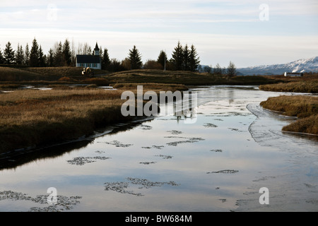 Rivière gelée semi-Oxara avec Thingvalla Kirkja église dans la distance, le Parc National de Thingvellir, Islande. Banque D'Images