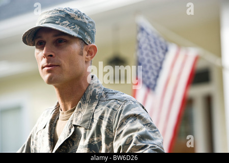 Mid-adult man en uniforme militaire, drapeau américain en arrière-plan Banque D'Images
