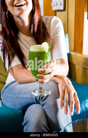 Jeune femme tenant un verre de jus biologiques sains Banque D'Images