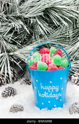 Un seau de bonbons de Noël décorative dans un désert de neige. Espace ouvert pour copier intentionnellement laissé dans le coin supérieur droit de l'arborescence. Banque D'Images
