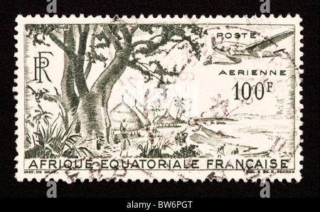 Timbre-poste de l'Afrique Équatoriale Française représentant un village et bord de mer. Banque D'Images