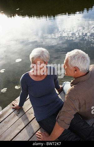 Senior couple flirting on jetty Banque D'Images