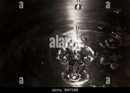 Frapper des gouttelettes de surface de l'eau. Banque D'Images