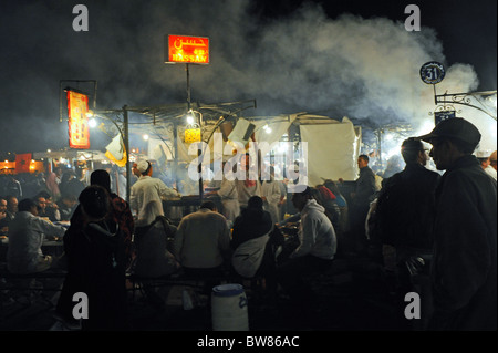 Vapeur et la fumée s'élève de la restauration rapide des stalles et restaurants qui sont mis en place dans la célèbre place Jemaa El Fna à Marrakech Banque D'Images