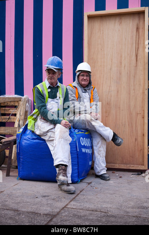 2 ouvriers ayant une pause et assis sur un sac de matériaux de construction, Buchanan Street, Glasgow Banque D'Images