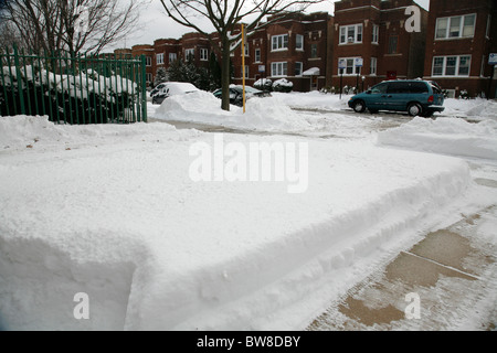 Les arbres couverts de neige à pied côté rue de la cour avant et les voitures en hiver dans le quartier de Chicago avec appartements Banque D'Images