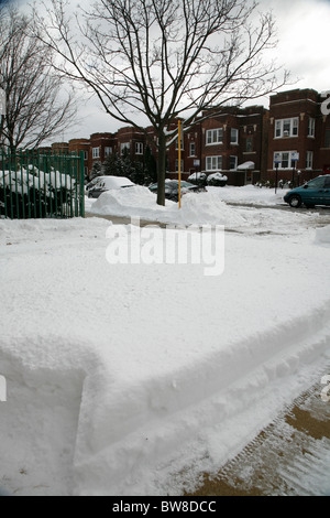 Les arbres couverts de neige à pied côté rue de la cour avant et les voitures en hiver dans le quartier de Chicago avec appartements Banque D'Images