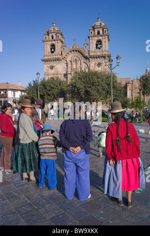 Famille autochtone sur la Plaza de Armes, l'église de la Compagnie de Jésus, Cuzco, Pérou Banque D'Images