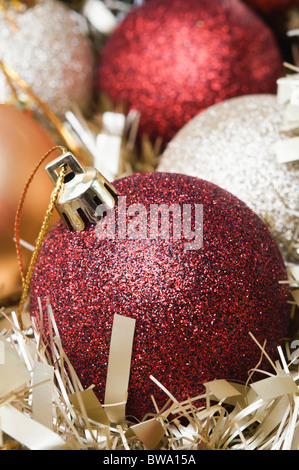 Rouge, argent et or boules de Noël niché dans l'or de guirlandes. Orientation verticale. Banque D'Images